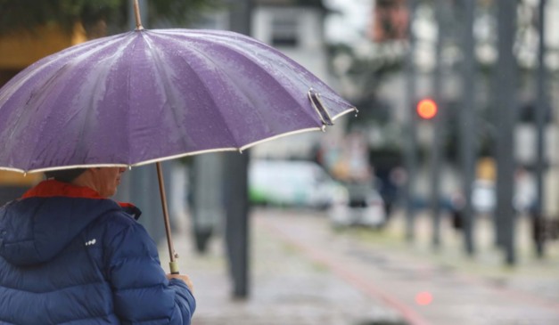 pessoa andando na chuva para ilustrar a previsão de temporal no paraná
