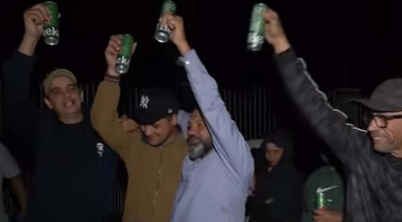 Grupo de pessoas com erguendo latinhas de cerveja