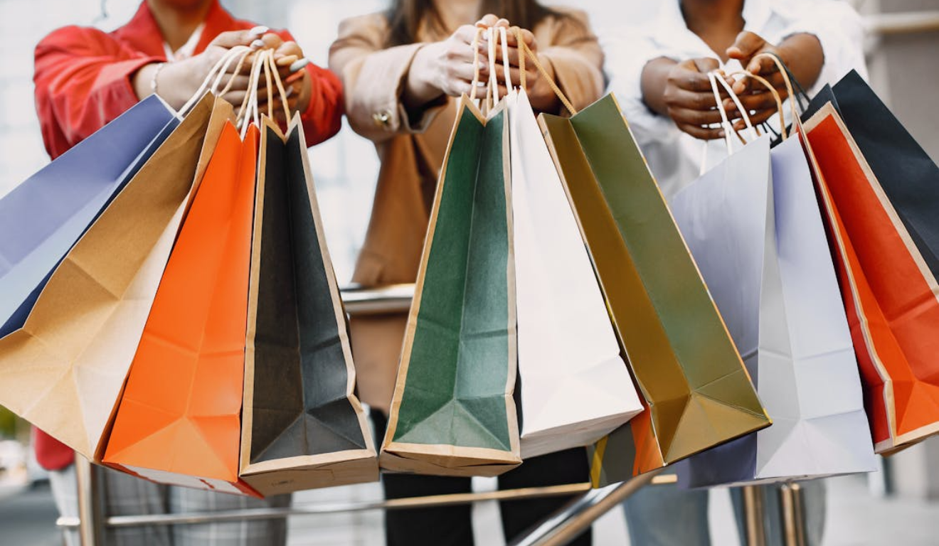 Imagem ilustrativa de três pessoas segurando sacolas.