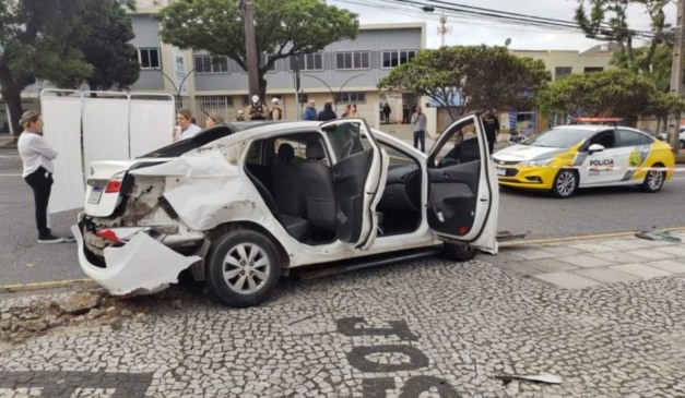 Local do acidente acompanhado por policiais militares, que observam carro de aplicativo, que mulher e filha estavam, antes de acidente com ônibus