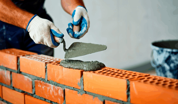 pedriro levantando parede de tijolos