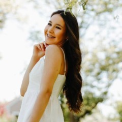 Anne Caroline Urbanski de Carvalho em foto de vestido branco em um parque dos Estados Unidos