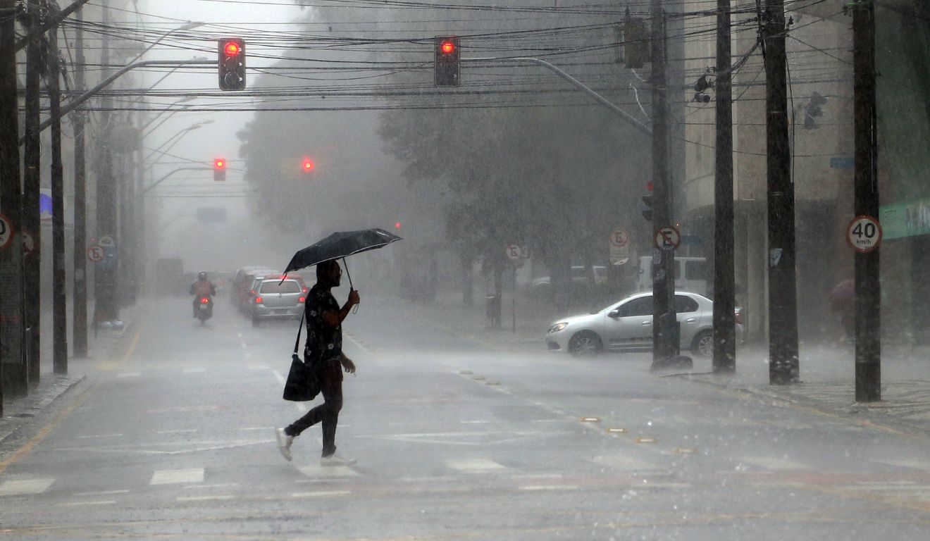 pessoa andando na chuva para ilustrar o alerta laranja para tempestade no paraná