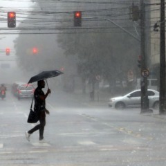 pessoa andando na chuva para ilustrar alerta laranja de tempestades no Paraná