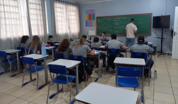 Sala de aula com alunos prestando atenção no professor