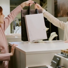 vendedora entregando sacola para cliente