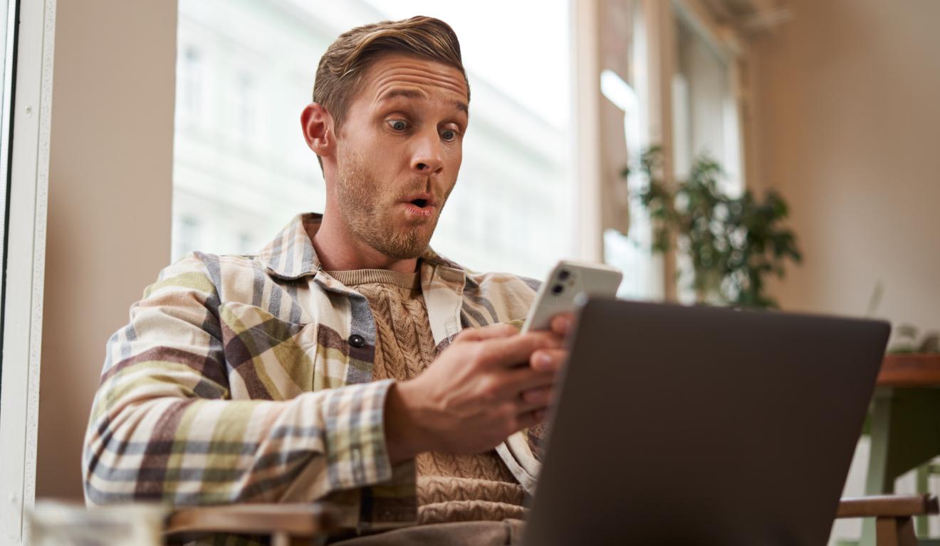 Homem assustado com pagamento em compra online e com a boca aberta