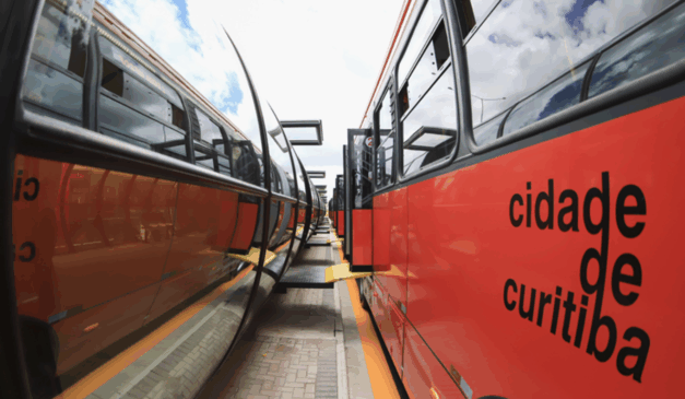 Curitiba pode ter botão antiassédio no transporte coletivo. Na imagem, vemos a lateral de um ônibus biarticulado de Curitiba parado em uma estação tubo.
