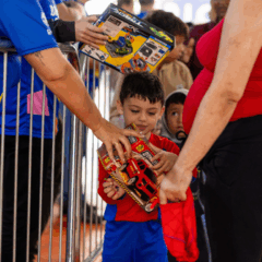 criança recebendo brinquedo durante a campanha brinquedo do bem 2025, promovido pelo instituto ric