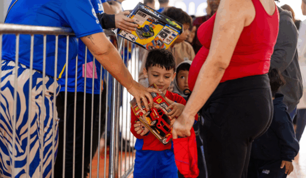 criança recebendo brinquedo durante a campanha brinquedo do bem 2025, promovido pelo instituto ric