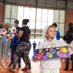 Momento em que criança pega entrega no Brinquedo do Bem