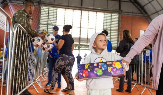 Momento em que criança pega entrega no Brinquedo do Bem