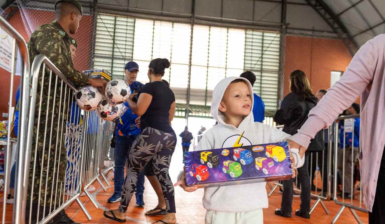 Momento em que criança pega entrega no Brinquedo do Bem
