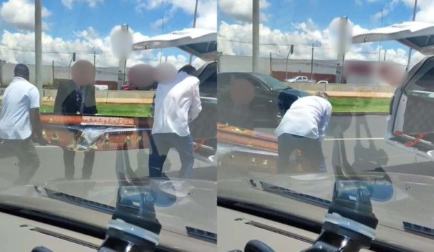 Motoristas de outros carros colocando caixão que caiu em carro funerário