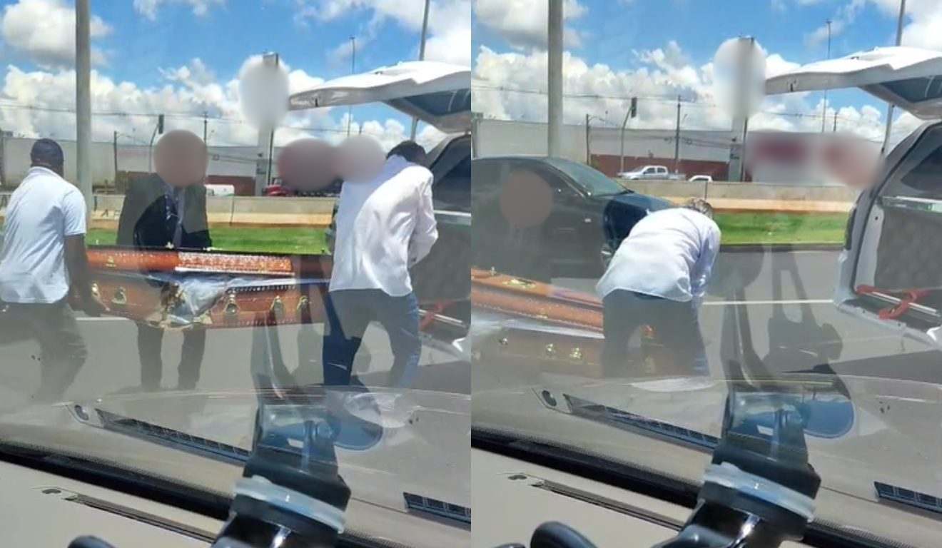 Motoristas de outros carros colocando caixão que caiu em carro funerário