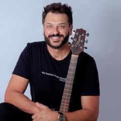 Cantor Ewerton Zanata em foto sentado com violão