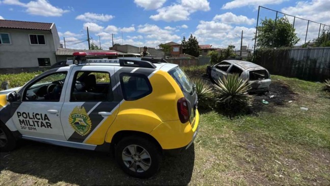 Viatura da Polícia Militar no local em que Clio foi encontrado incendiado.