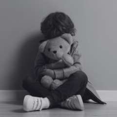 Casal é condenado pelo estupro da sobrinha. Na imagem ilustrativa, em preto e branco, vemos uma criança sentada com as pernas cruzadas, escondendo o rosto com um urso de pelúcia.