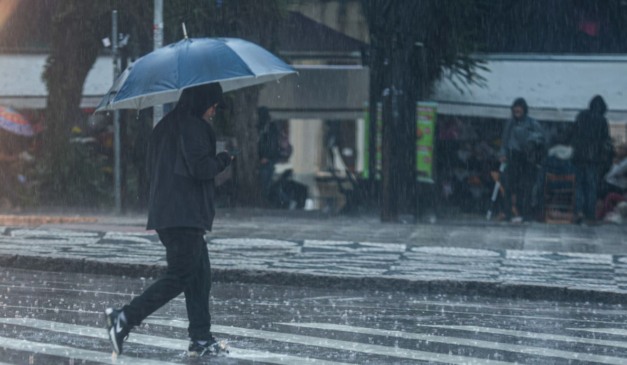 pessoa andando na chuva no paraná