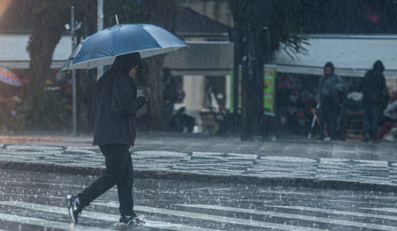 pessoa andando na chuva no paraná