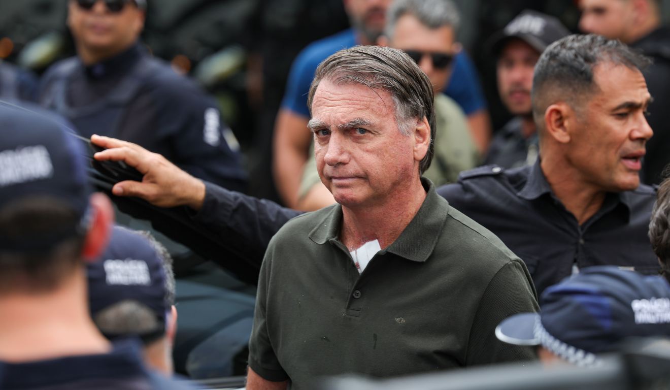 Jair Bolsonaro cercado por agentes de segurança