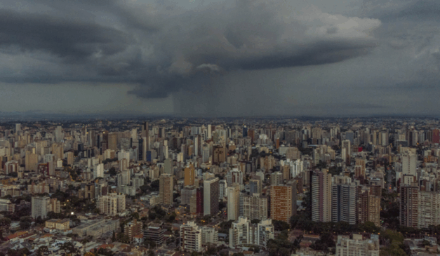 Curitiba pode ter tempestades no fim de semana. Na imagem, vemos uma vista aérea da capital paranaense, com céu nublado e chuvoso.