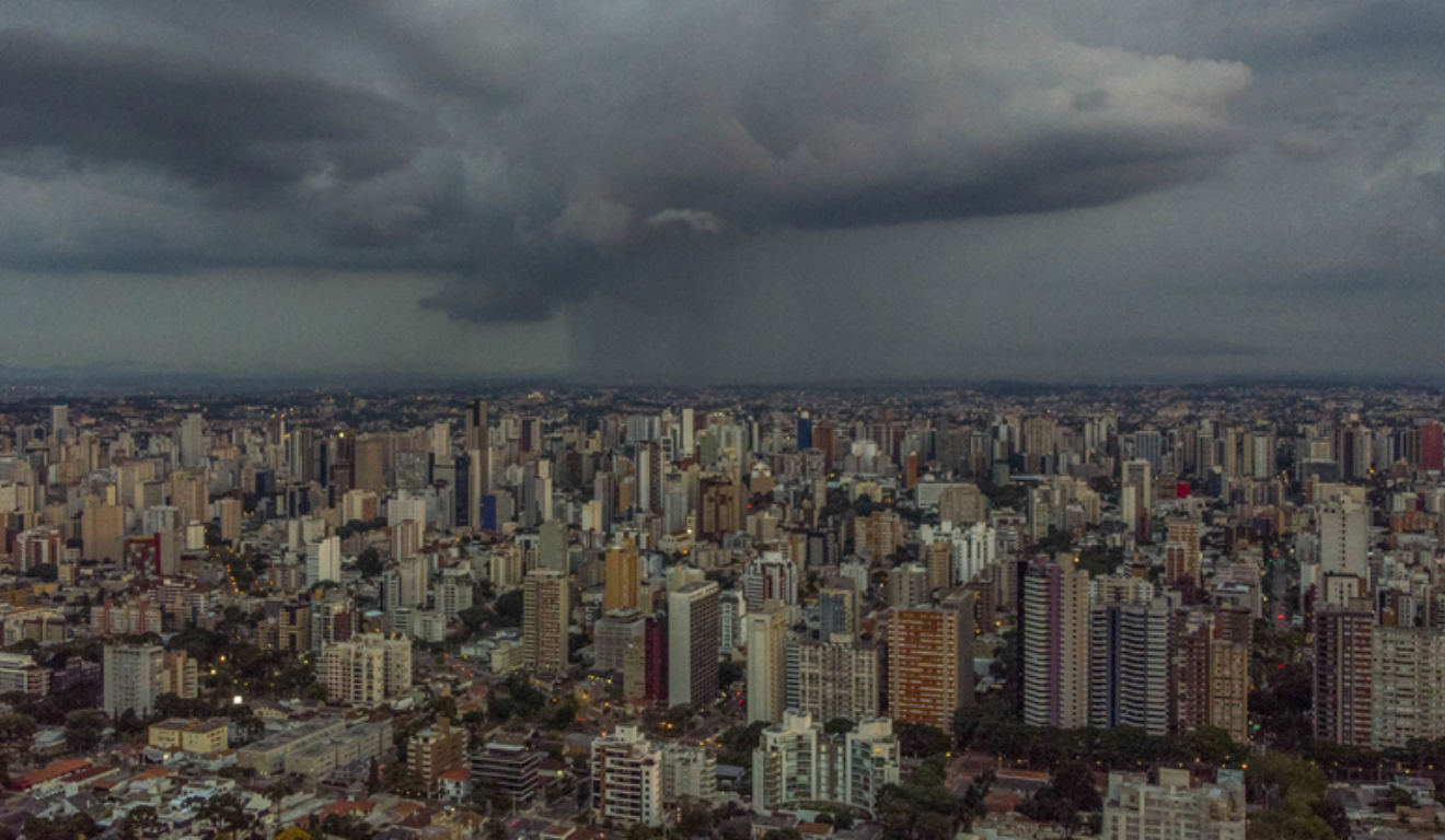 Curitiba pode ter tempestades no fim de semana. Na imagem, vemos uma vista aérea da capital paranaense, com céu nublado e chuvoso.