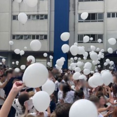 crianças com balões brancos para homenagem a estudante baleada em frente ao colégio