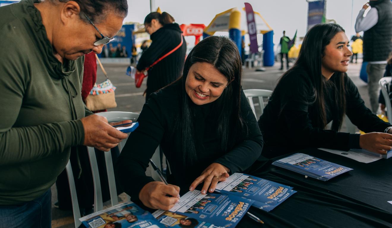 pessoas preenchendo cupons no Festival de Prêmios, da Ric RECORD
