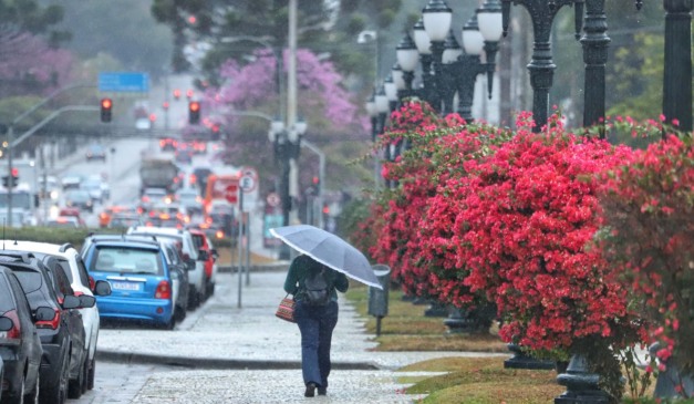 mulher andando na chuva para ilustrar a chegada da frente fria em curitiba
