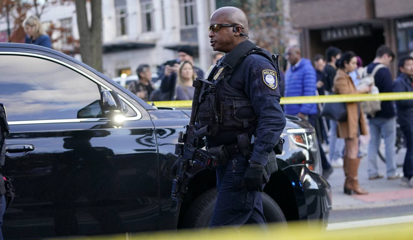 Policial caminhando área isolada onde guardas foram baleados nos estados unidos