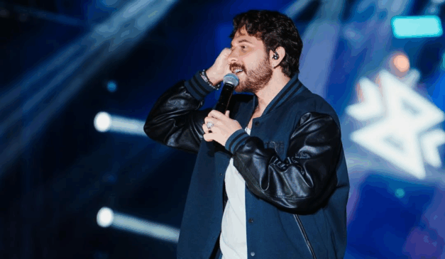 Imagem de Gustavo Mioto cantando.