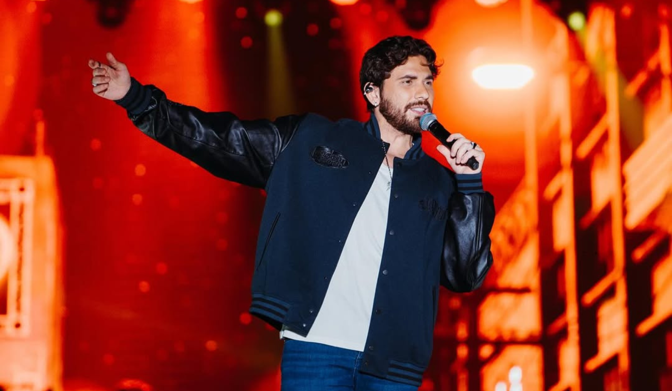 Imagem de Gustavo Mioto cantando.