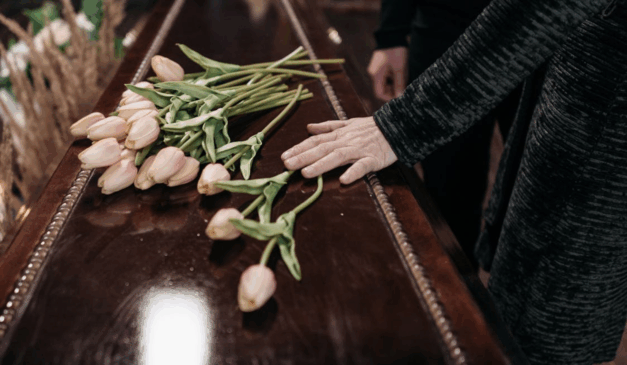 Imagem ilustrativa de um caixão com flores.