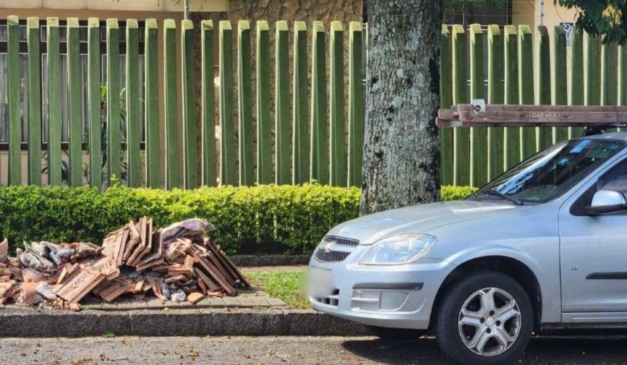 Telhas em calçada após idoso cair de telhado de casa em Curitiba