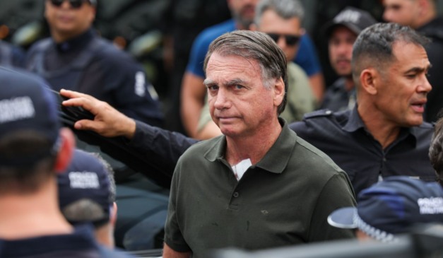 Jair Bolsonaro próximo a veículo e com vários agentes de segurança em volta