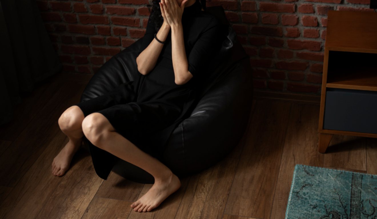 Jovem sozinha chorando em sofá de casa