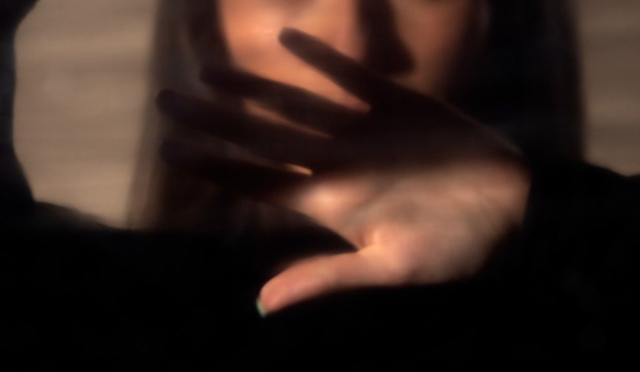 foto de mulher com a mão protegendo o rosto