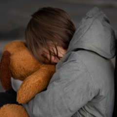 Criança chorando segurando um urso