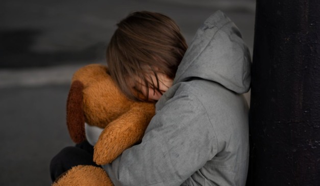 Criança chorando segurando um urso