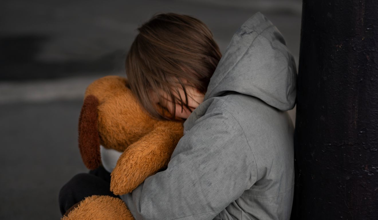 Criança chorando segurando um urso