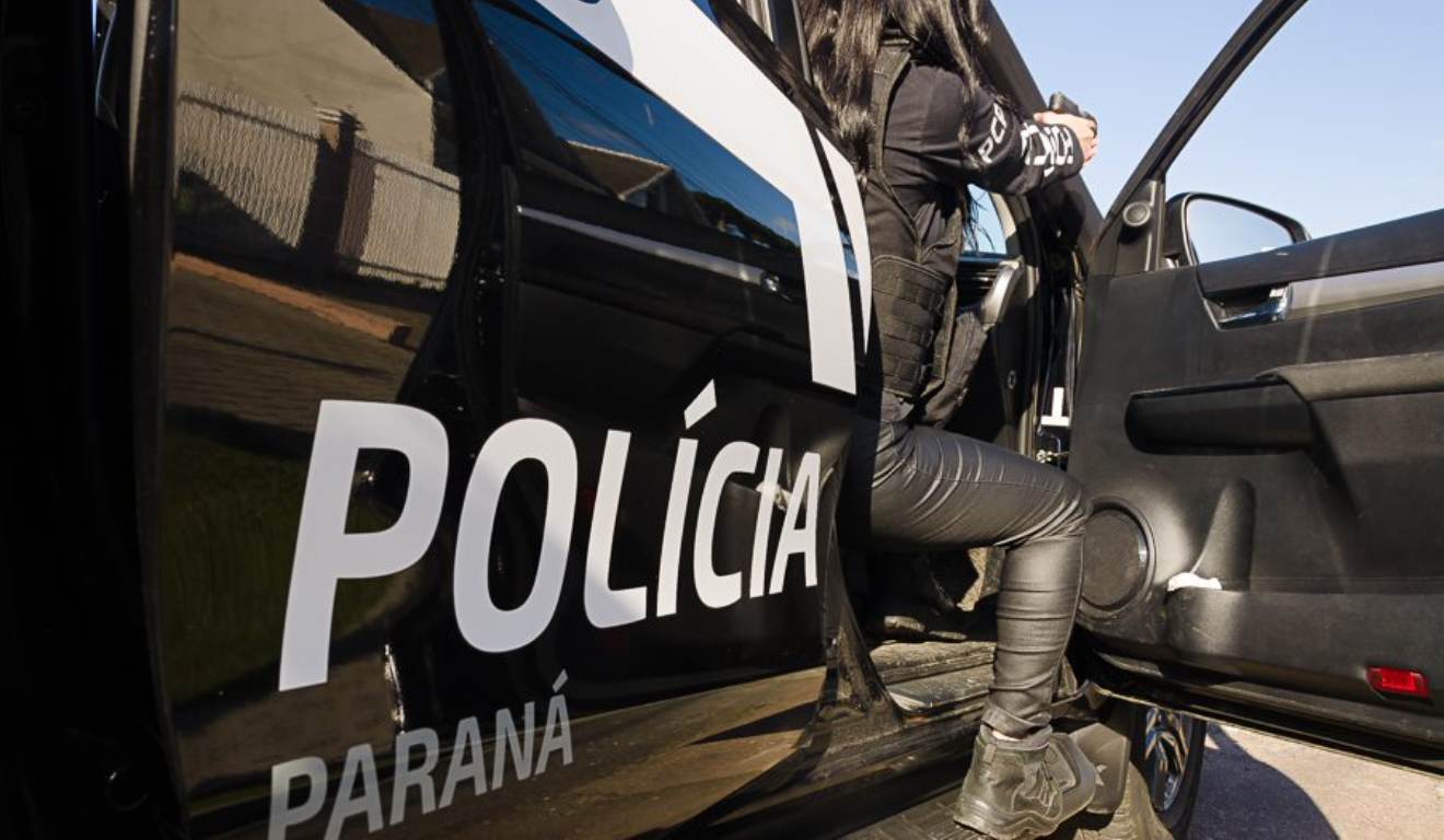 Viatura da Polícia Civil do Paraná com uma agente na porta