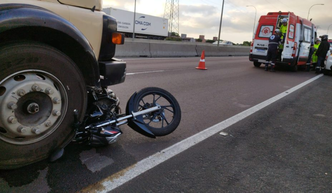 Um motociclista foi atropelado por um caminhão após colidir com um carro. Na imagem, vemos o caminhão sobre a motocicleta.