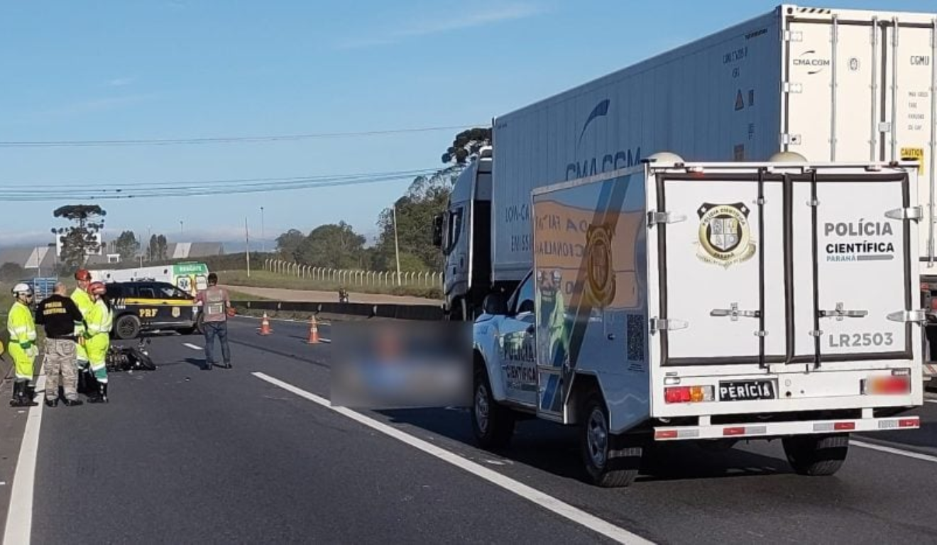 Um motociclista morreu atropelado por um caminhão na Grande Curitiba. Na imagem, vemos a rodovia, com o corpo no chão, borrado para preservar o anonimato da vítima.