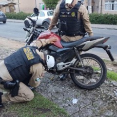 Policiais vendo moto envolvida em acidente que jovem atropelou mulheres