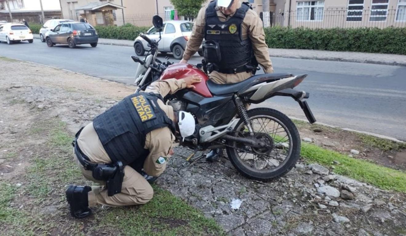Policiais vendo moto envolvida em acidente que jovem atropelou mulheres