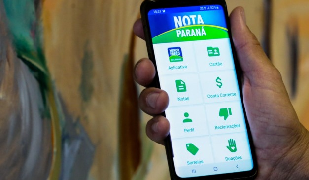 Mão segurando celular com o app do programa Nota Paraná aberto