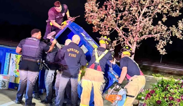 Equipe de resgate tentando tirar homem da caixa.