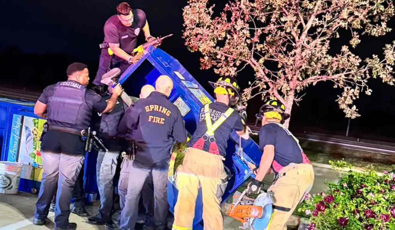Equipe de resgate tentando tirar homem da caixa.