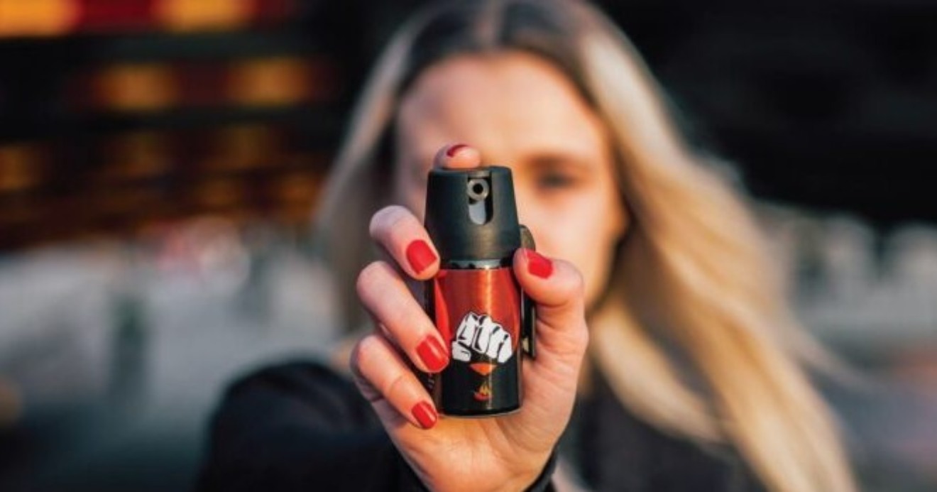 Mulher segura spray de pimenta